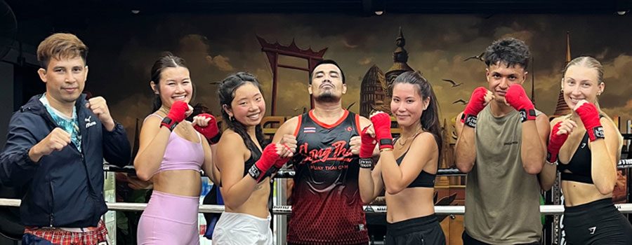 Group of Muay Thai students posing together inside a boxing ring in Koh Phi Phi.
