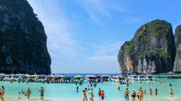 Maya Bay crowded 2026 context, showing multiple boats anchored inside the bay before regulations