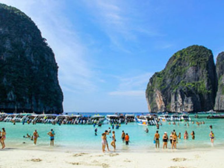 Maya Bay crowded 2026 context, showing multiple boats anchored inside the bay before regulations
