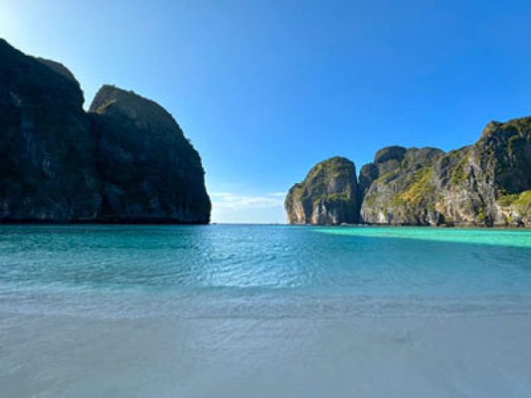 Maya Bay during a quiet late afternoon, with an empty beach in the shade